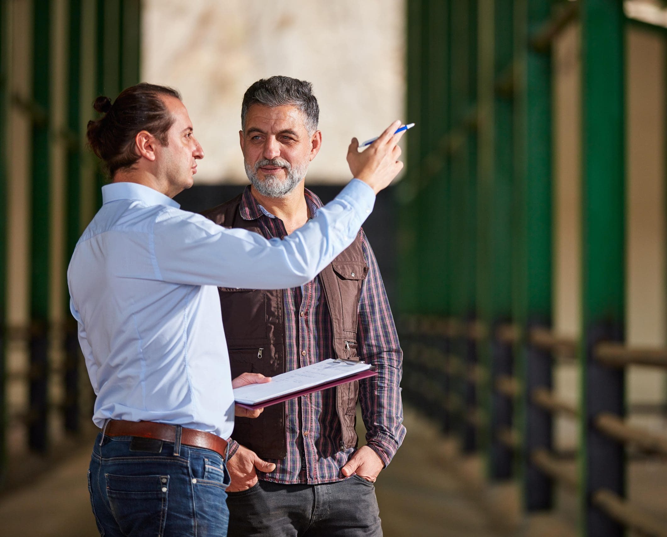 Financial adviser discussing succession planning with a farmer inside an agricultural building.