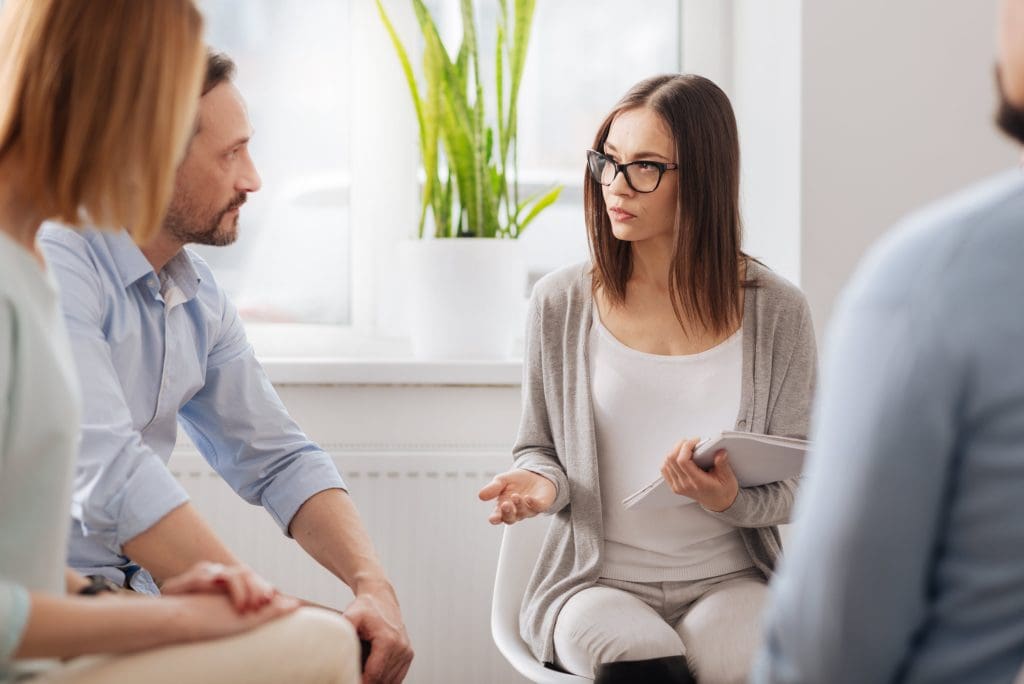A mediator or family law professional facilitating a discussion between a couple during a family dispute resolution session.