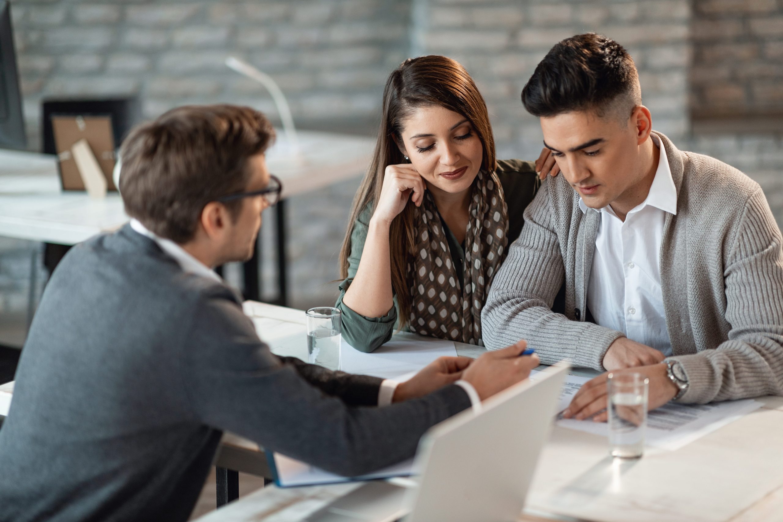 Mortgage adviser discussing options with a couple during a financial planning meeting.